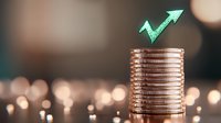 Stack of shiny copper coins with glowing mint green arrow pointing upward, symbolizing financial growth and investment success against blurred bokeh background.