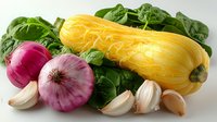 Fresh yellow squash with red onions, garlic cloves and green spinach leaves arranged on white surface, bright natural lighting creates appetizing composition.