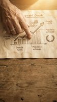 Senior businessman hand pointing at growth chart on paper showing milestone achievements and development progress for business planning presentations.