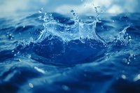 Dynamic water splash captured in deep blue ocean creating crown-shaped droplets and ripples against blurred aquatic background. Perfect for environmental themes.