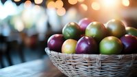Fresh colorful plums in woven basket against blurred bokeh background, mix of ripe green and purple fruits creating appetizing composition.