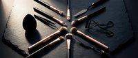 Professional makeup brushes arranged in circular pattern on dark slate surface with dramatic lighting for beauty and cosmetics applications.