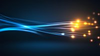 Glowing blue and orange light streams flow across dark background creating dynamic energy effect with luminous particles and waves for technology designs.