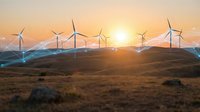 Wind turbines generating clean renewable energy at sunset over rolling hills with golden sky and mountain backdrop for sustainable power concepts.