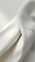 Close-up of soft, flowing white fabric with delicate folds and gentle curves, showcasing texture and drape for textile, fashion, and design projects.