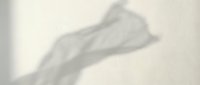 Hand shadow silhouette on beige wall creating artistic gesture shape for creative design projects and minimalist aesthetic concepts.