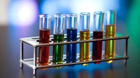 Laboratory test tubes with colorful chemical solutions in metal rack for scientific research and experimentation in modern lab setting.