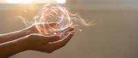 Hand holding glowing energy orb with pink and golden light effects, representing power, magic, innovation, and spiritual concepts for design projects.