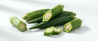 Fresh green okra pods with sliced pieces showing seeds, healthy organic vegetable ingredient for cooking and nutrition on white background.