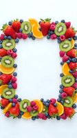 Fresh mixed berries and citrus fruits arranged in rectangular frame border on white background for healthy eating and nutrition concepts.