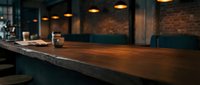 Empty modern bar counter with wooden top and dark interior, featuring warm ambient lighting and brick walls, suitable for hospitality and restaurant design projects.