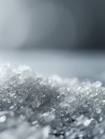Macro shot of crystalline frost formation with delicate ice crystals creating abstract winter texture against blurred gray background, selective focus highlights natural patterns.