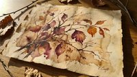 Autumn watercolor painting on vintage paper featuring delicate branch with colorful fall leaves in warm browns and burgundy tones for seasonal decor.
