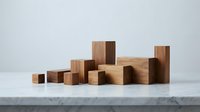 Wooden blocks arranged in ascending bar chart formation on marble surface, representing growth, progress, and business success metrics.