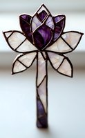 Stained glass lotus flower in purple and white with metal frame, decorative suncatcher design featuring geometric petals and elegant stem pattern.