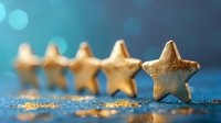 Golden star-shaped cookies lined up on sparkling blue surface with bokeh lights in background, creating festive holiday atmosphere for Christmas or celebration.