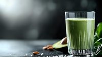 Fresh green smoothie with celery, cucumber and herbs in glass on dark background with natural light and copy space. Healthy detox drink.