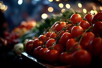 Fresh cherry tomatoes on vine with soft bokeh lights in background, vibrant red produce displayed at market, shallow depth of field creates dreamy atmosphere.