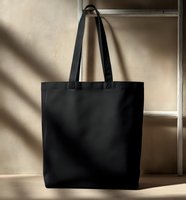 Black cotton tote bag hanging on wooden ladder against beige wall with natural shadow play, perfect for eco-friendly shopping or brand mockup.