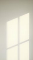 Sunlight streaming through window panes creates geometric shadows on neutral wall, ideal for backgrounds and design overlays.