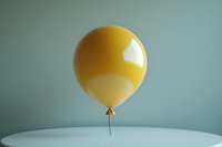 Yellow balloon floating against mint green wall, minimalist composition with soft shadows and reflective surface, isolated on round white table.