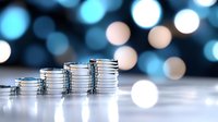 Stacks of silver coins showing financial growth with soft blue bokeh background, representing wealth, investment and economic success in business concept.