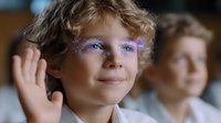 Young boy with curly blonde hair and creative purple glitter makeup around eyes waves and smiles warmly at camera, expressing joy and playful spirit.