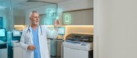 Senior male doctor in white coat using digital healthcare technology interface with holographic medical icons in modern hospital setting.