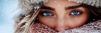 Young woman with striking blue eyes wearing knit winter hat and scarf in snowy weather. Cold season portrait with snowflakes for fashion and lifestyle content.