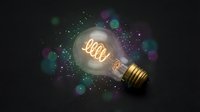 Glowing light bulb with illuminated filament spelling word against dark background with colorful bokeh lights and sparkling particles for creative concepts.