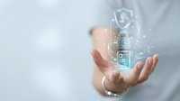 Business professional displaying holographic cybersecurity icons with shield and lock symbols above open palm for data protection and digital security concepts.