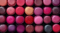 Colorful lipstick collection arranged in rows showing various shades of pink, red, purple and berry tones for beauty and cosmetics industry use.