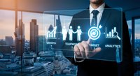 Professional businessman touching digital interface with business analytics icons including growth charts, teamwork, target and data visualization in modern office setting.