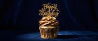 Golden Happy Birthday cupcake with chocolate frosting and glitter topper on dark blue background, elegant celebration dessert.