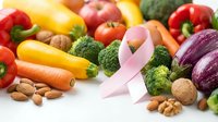 Fresh colorful vegetables, nuts, and a pink ribbon symbolizing breast cancer awareness, promoting healthy nutrition and disease prevention.
