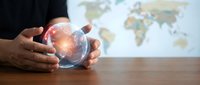 Businessman hands holding glowing crystal ball with world map background for global business forecasting and future planning concepts.