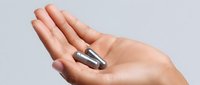Silver metallic capsule pills on open palm against light background, demonstrating medical supplement or pharmaceutical concept for healthcare marketing.