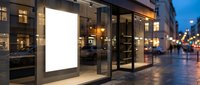 Blank white billboard display on modern storefront at twilight with warm interior lighting and wet pavement reflecting city lights for advertising mockup.