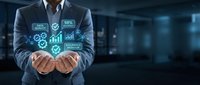 Professional businessman in suit holding glowing digital icons representing business analytics, data management and technology solutions in modern office.