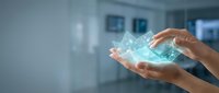 Young adult with medium skin tone holding glowing digital holographic data visualization in hands against blurred modern office background, representing technology innovation and data management.