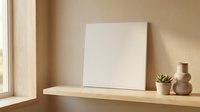 Blank white canvas on wooden shelf with small succulent plant and ceramic vase in warm sunlit room interior for mockup and design projects.