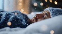 Young African American woman sleeping peacefully in bed wearing winter knit hat, with soft bokeh lights and snowfall creating dreamy atmosphere for winter season concept.