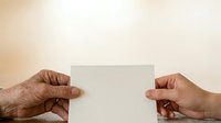 Two hands holding blank white card against neutral beige background, suitable for business messaging, greeting cards, and promotional content.