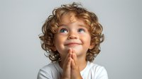 Caucasian child with curly blonde hair and blue eyes wearing white t-shirt, making praying or wishing gesture while looking up with hopeful expression against light background.