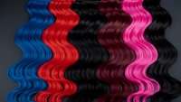 Colorful wavy hair extensions in blue, red, black, burgundy and pink creating flowing waves pattern for beauty salon and hairstyling concepts.