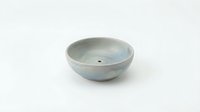 Ceramic bowl with pale blue-green glaze and drainage hole, isolated on white background, suitable for product design, home decor, and craft projects.
