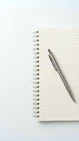 Open spiral notebook with lined pages and silver pen on white background for office supplies and stationery design projects.