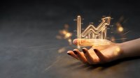 Glowing upward trending arrow and bar chart hologram floating above open hand, symbolizing financial growth, business success, and data analytics for investment and market analysis.