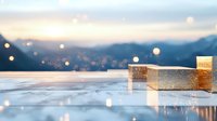 Elegant gold geometric shapes on reflective surface against blurred mountain landscape at sunset with bokeh light effects.
