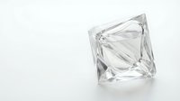 Clear crystal diamond shape glass object on white background isolated for jewelry design and luxury product presentations.